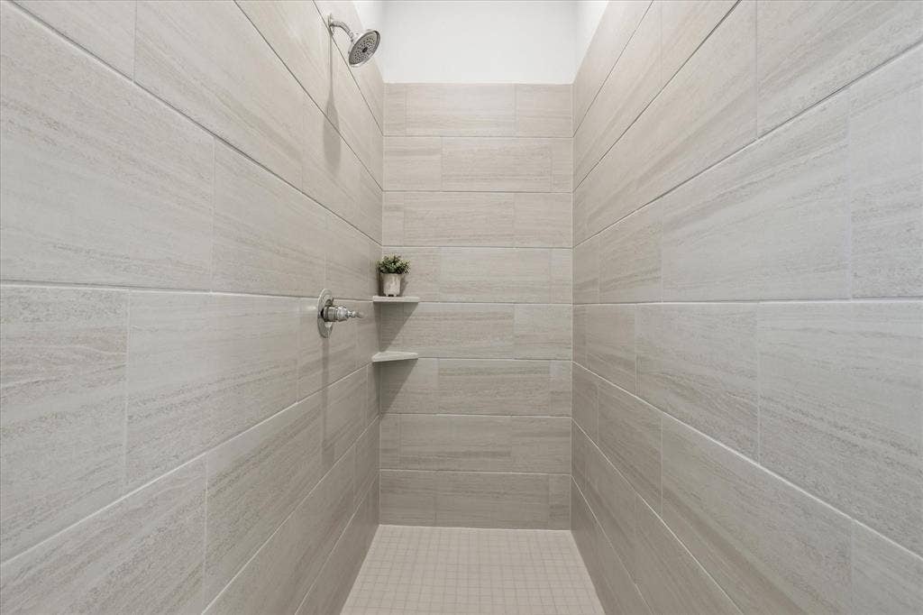 4017 Alpine Street, Midlothian, TX 76065 Walk-in shower featuring light-toned tile walls, a mosaic tile floor, and chrome fixtures