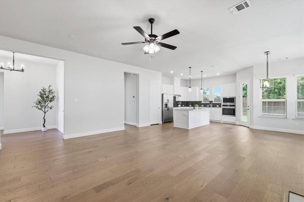 4017 Alpine Street, Midlothian, TX 76065 Spacious open-concept interior featuring light wood-finish flooring throughout