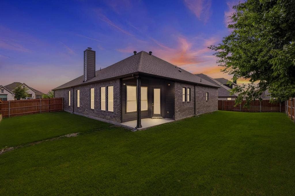 4017 Alpine Street, Midlothian, TX 76065 Spacious backyard with dark brick exterior and a covered patio
