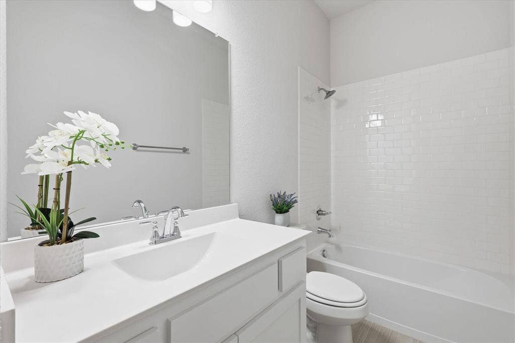 4017 Alpine Street, Midlothian, TX 76065 Bathroom featuring a white vanity with integrated sink, chrome faucet, and a large wall-mounted mirror