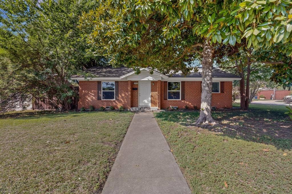 405 Easton Road, Dallas, TX 75218 Red brick facade with white trim, featuring a central entryway and prominent front windows with dark shutters