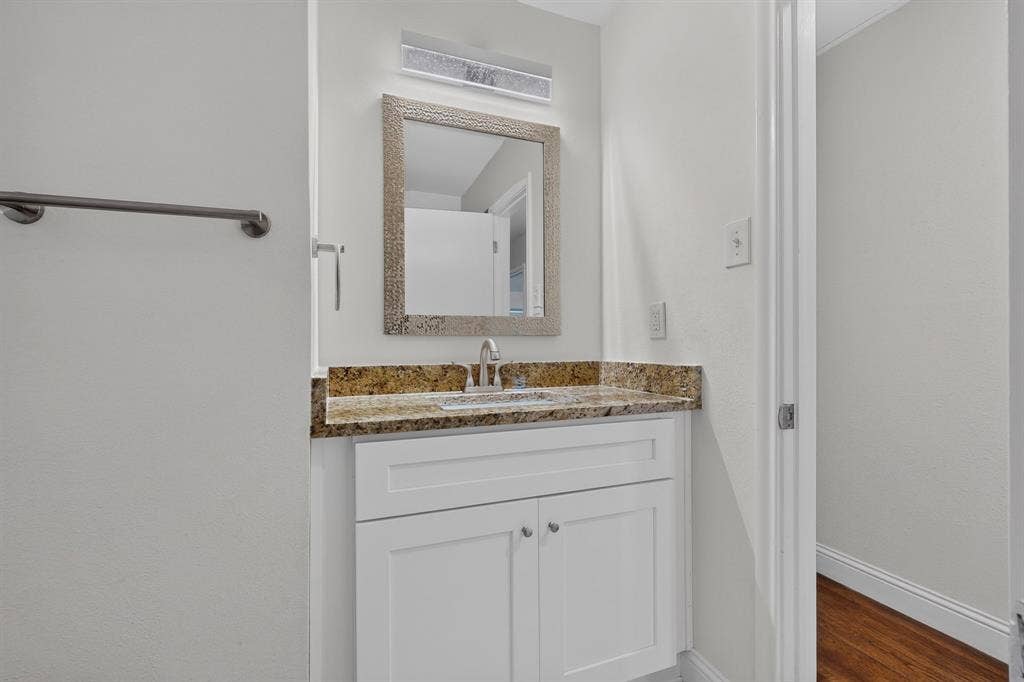 405 Easton Road, Dallas, TX 75218 White vanity with shaker-style cabinetry, a granite countertop, and an undermount sink