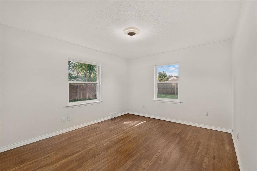 405 Easton Road, Dallas, TX 75218 Bright interior space featuring wood-finish flooring, white baseboards, and neutral wall tones