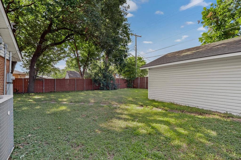405 Easton Road, Dallas, TX 75218 Expansive fenced yard with mature trees and a detached garage featuring white siding