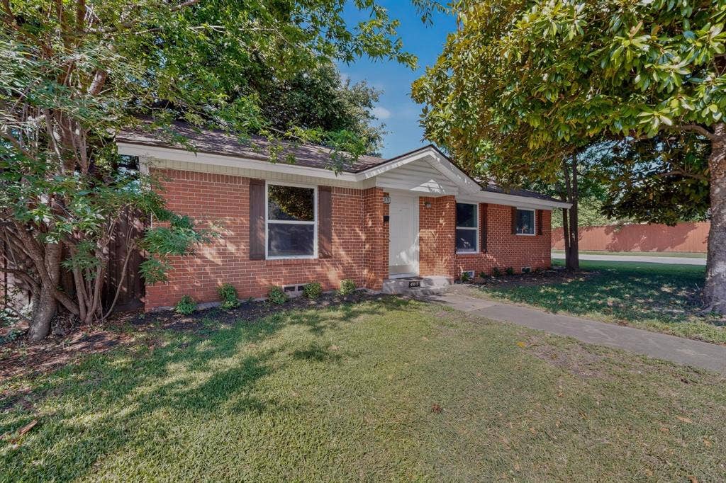 405 Easton Road, Dallas, TX 75218 Brick exterior with white trim, brown shutters, and a covered entry