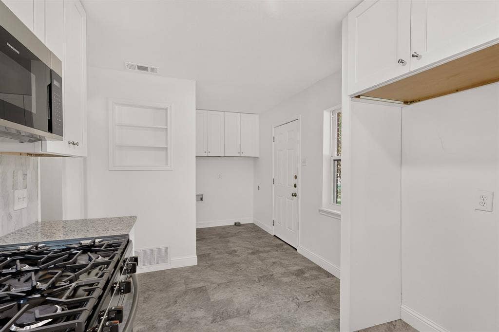 405 Easton Road, Dallas, TX 75218 Kitchen featuring a stainless steel gas range, stone-finish countertops, white shaker cabinetry, and an over-range microwave