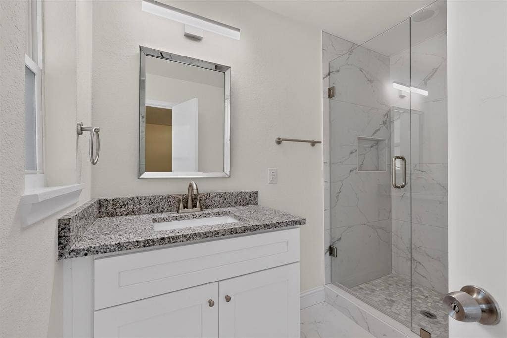 405 Easton Road, Dallas, TX 75218 Bathroom featuring a white vanity with a granite countertop, undermount sink, and brushed nickel faucet