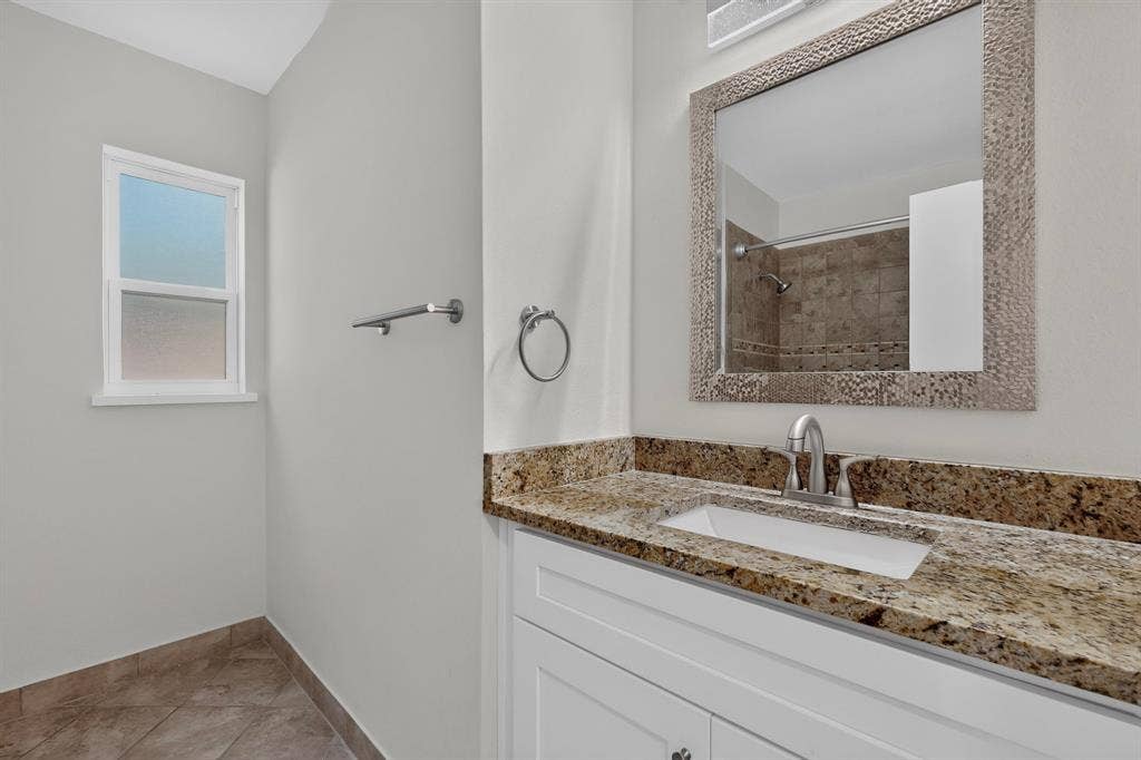 405 Easton Road, Dallas, TX 75218 Bathroom vanity featuring a light-toned granite countertop with an undermount sink and brushed nickel faucet