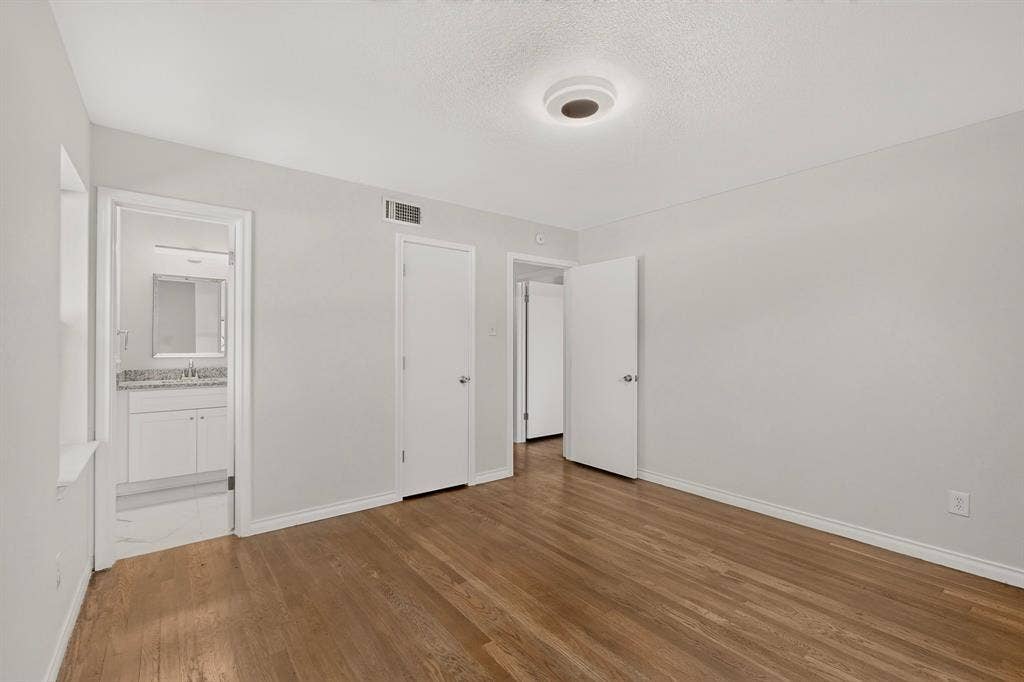 405 Easton Road, Dallas, TX 75218 Interior room featuring wood-finish flooring, light-toned wall paint, and a flush-mount ceiling light