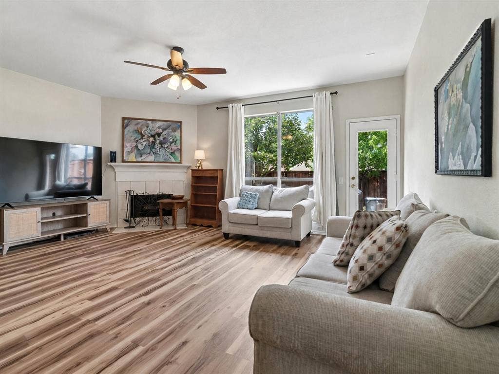 11379 Lockshire Drive, Frisco, TX 75035 Wood-finish flooring, ceiling fan, fireplace with mantel, sliding glass door, and exterior door
