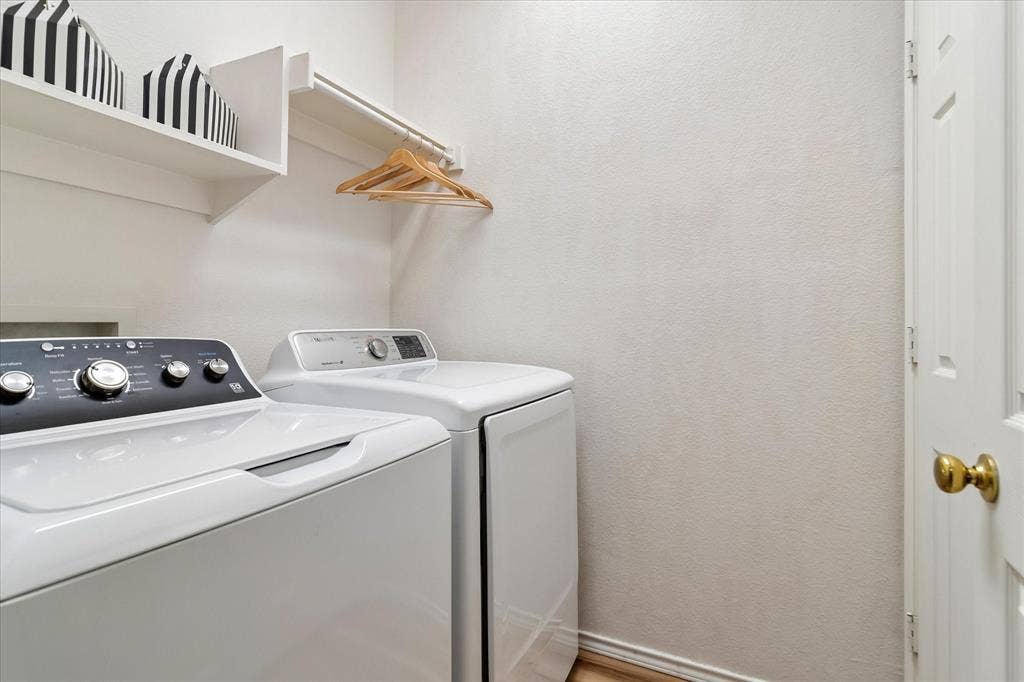 11379 Lockshire Drive, Frisco, TX 75035 Laundry area featuring a built-in shelving unit, a wall-mounted hanging rod, and wood-finish flooring