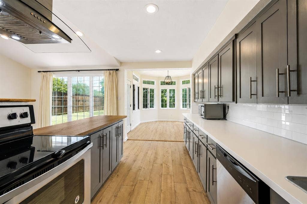 Kitchen featuring wood-finish flooring, recessed lighting, gray cabinetry, light countertops, and a subway tile backsplash