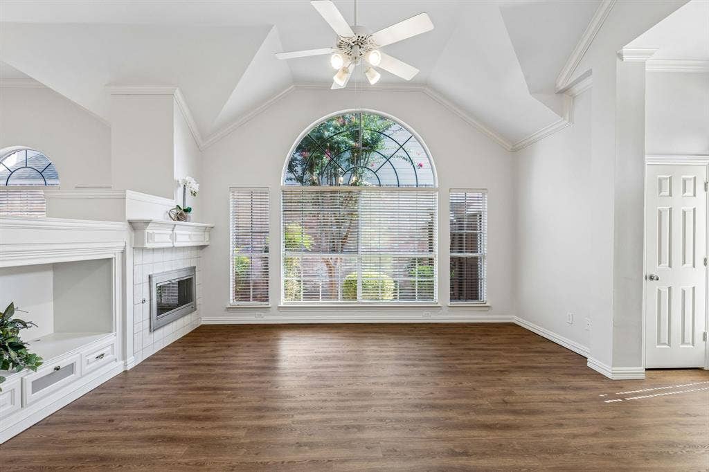 6852 High Field Trail, Plano, TX 75023 Living space featuring wood-finish flooring, vaulted ceilings, and a large arched window with transom detailing