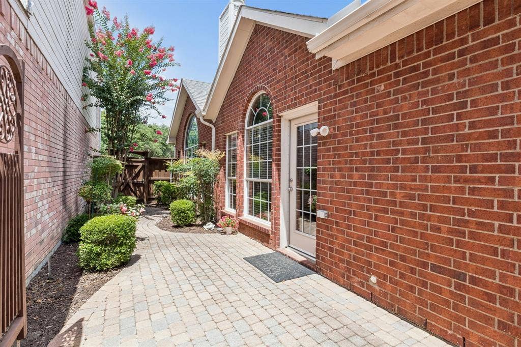 6852 High Field Trail, Plano, TX 75023 Brick exterior with arched windows and a white paneled door
