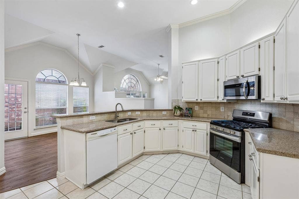 6852 High Field Trail, Plano, TX 75023 Kitchen featuring white cabinetry, granite countertops, stainless steel appliances, and tile flooring