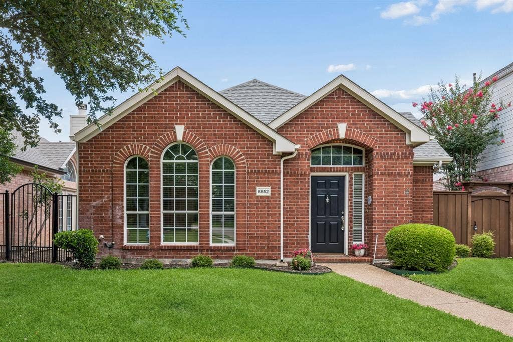 6852 High Field Trail, Plano, TX 75023 Brick facade featuring an arched entryway and multiple arched windows