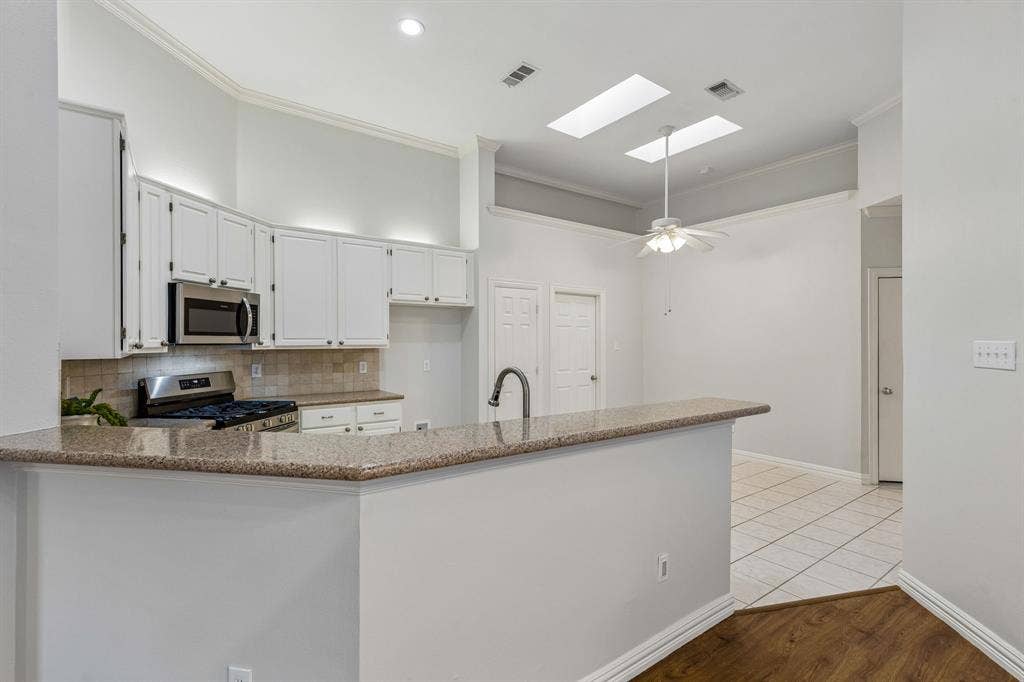 6852 High Field Trail, Plano, TX 75023 Kitchen featuring white cabinetry with stainless steel appliances, granite countertops, and a tiled backsplash