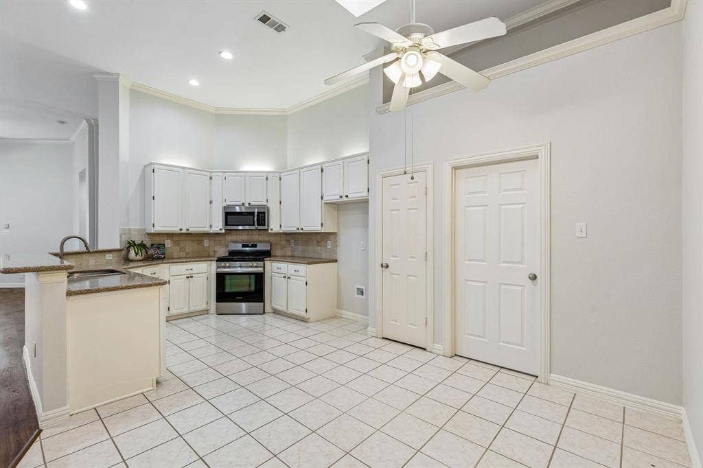 6852 High Field Trail, Plano, TX 75023 Kitchen featuring white cabinetry, stainless steel appliances, tile backsplash, and granite countertops