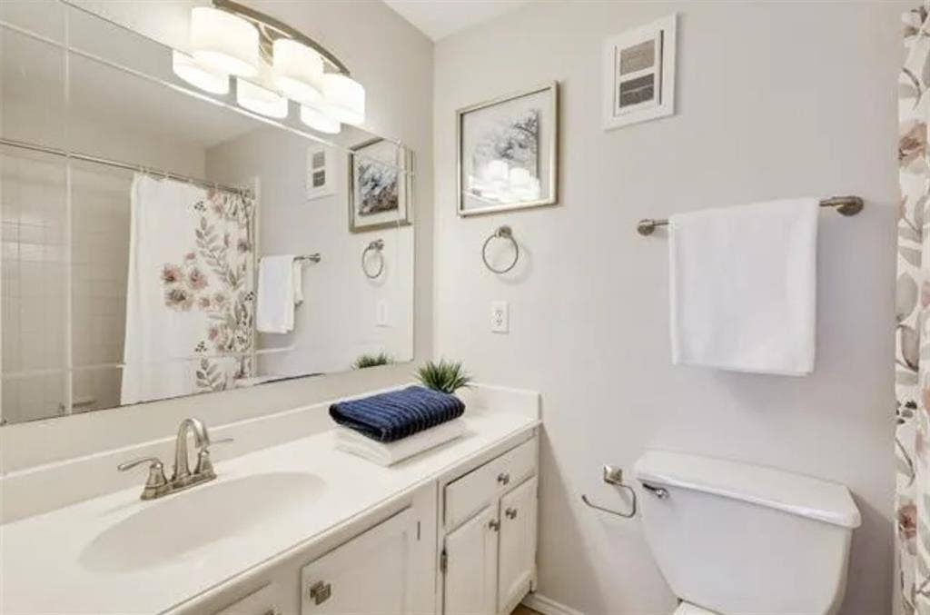 8400 Hickory Street, #1504, Frisco, TX 75034 Bathroom featuring a vanity with a drop-in sink, white cabinetry, and a full-width mirror