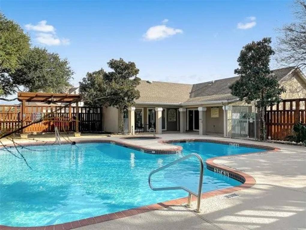 8400 Hickory Street, #1504, Frisco, TX 75034 Resort-style swimming pool featuring an irregular shape, concrete decking, and a red brick coping