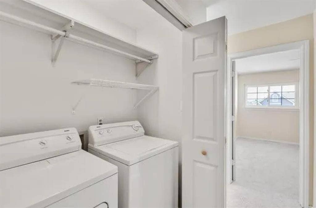 8400 Hickory Street, #1504, Frisco, TX 75034 Dedicated laundry area featuring a full-sized washer and dryer, white shelving, and a hanging rod
