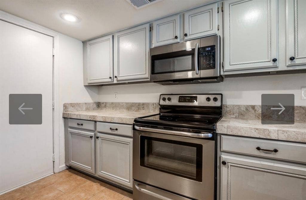 8400 Hickory Street, #1504, Frisco, TX 75034 Kitchen featuring light gray cabinetry with dark hardware, stone-finish countertops with a matching backsplash, a stainless steel over-the-range microwave, and a stainless steel electric range