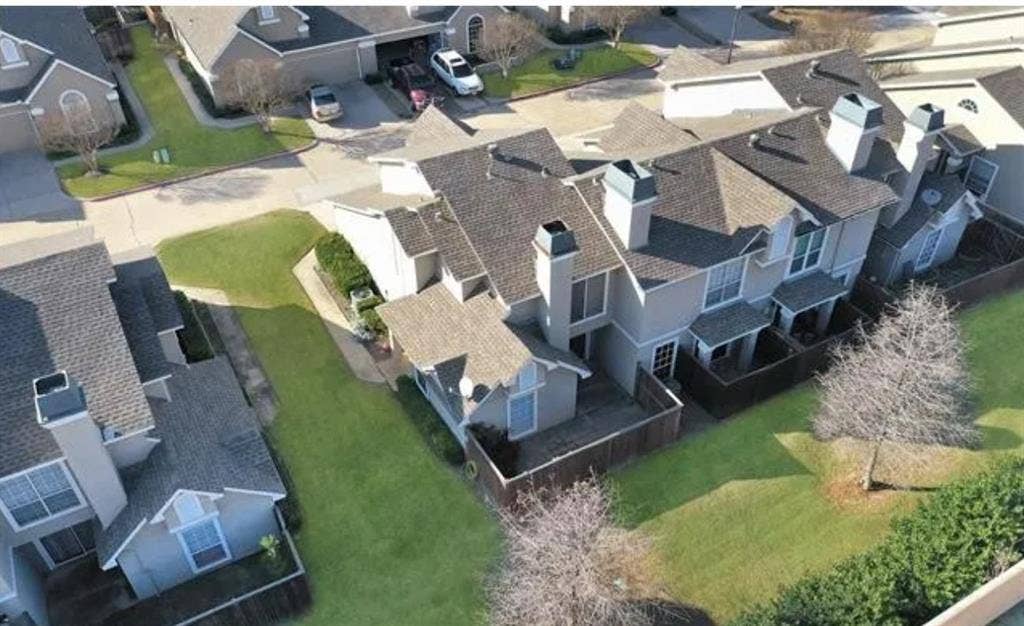 8400 Hickory Street, #1504, Frisco, TX 75034 Townhome exterior featuring multiple chimneys, a private fenced patio, and varied rooflines