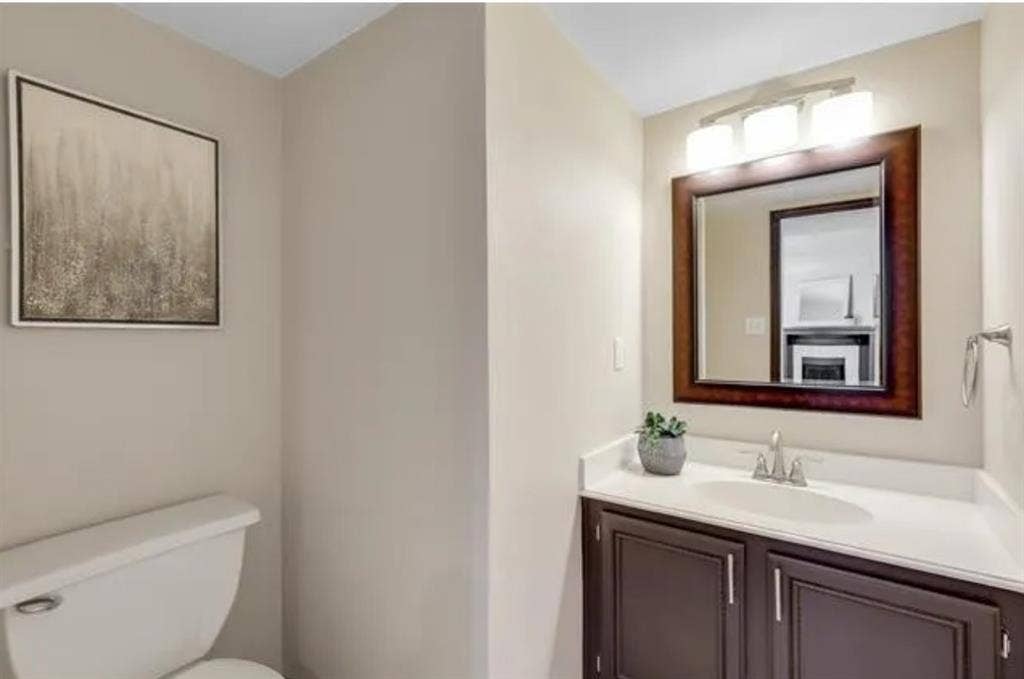 8400 Hickory Street, #1504, Frisco, TX 75034 Vanity featuring a white countertop, undermount sink, and dark wood-finish cabinetry