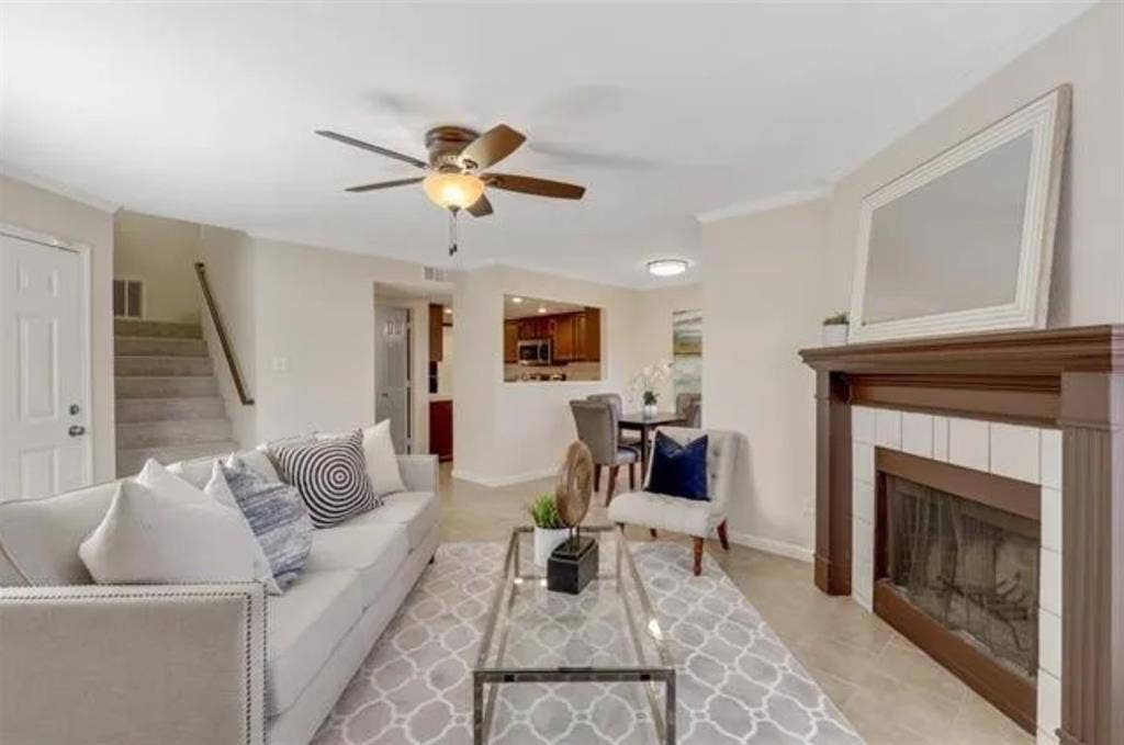 8400 Hickory Street, #1504, Frisco, TX 75034 Living area featuring a traditional fireplace with a white tile surround and a wood mantel
