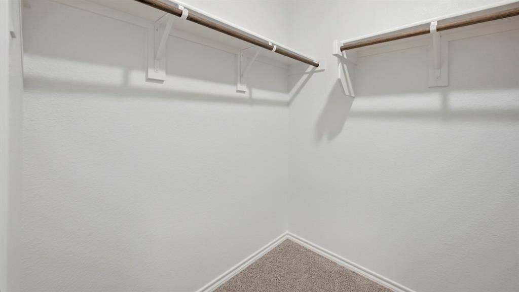 5032 Shumard Drive, Lindale, TX 75771 Corner closet space featuring white walls, white baseboards, and neutral-toned carpet