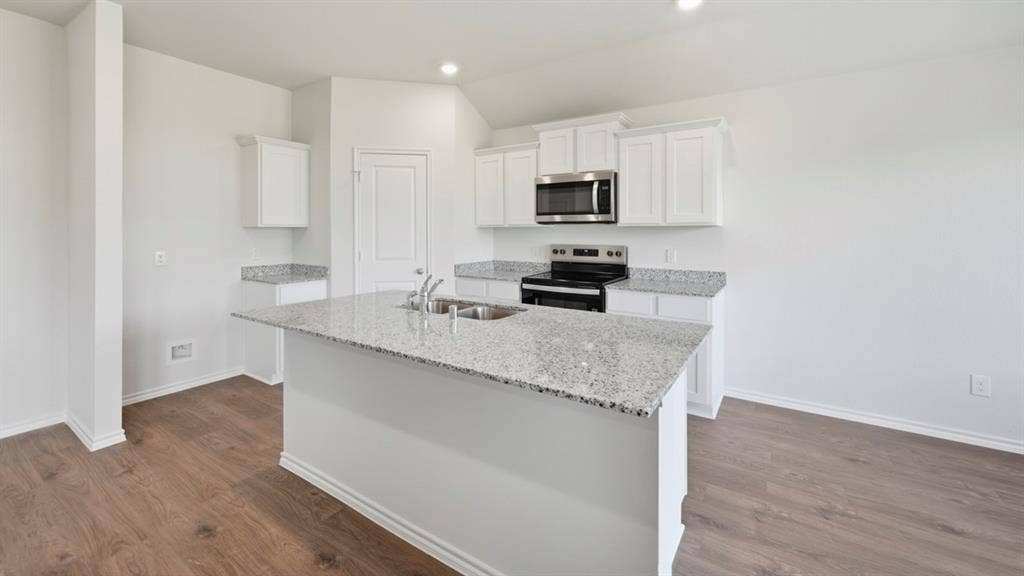 5032 Shumard Drive, Lindale, TX 75771 Spacious kitchen featuring an island with a double basin stainless steel sink, granite countertops, white cabinetry, and wood-finish flooring