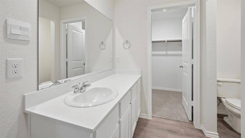 5032 Shumard Drive, Lindale, TX 75771 Bathroom vanity featuring a white countertop with an integrated sink, chrome faucet, and a large wall-mounted mirror