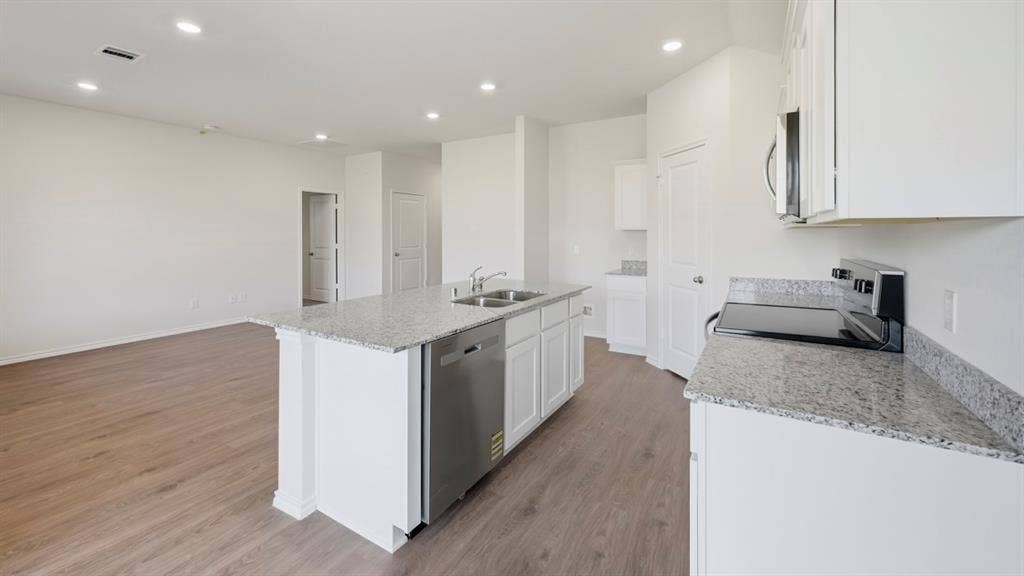 5032 Shumard Drive, Lindale, TX 75771 Spacious kitchen featuring an island with a double basin sink, stainless steel dishwasher, and granite countertops