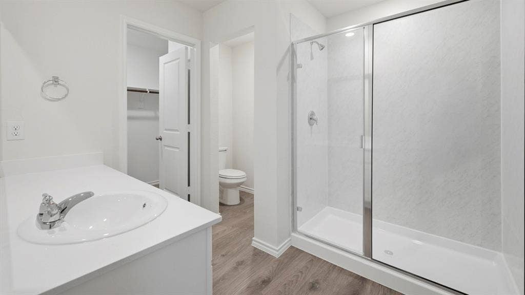 5032 Shumard Drive, Lindale, TX 75771 Bathroom featuring a single vanity with an integrated sink, chrome faucet, and a spacious glass-enclosed shower with a white shower pan