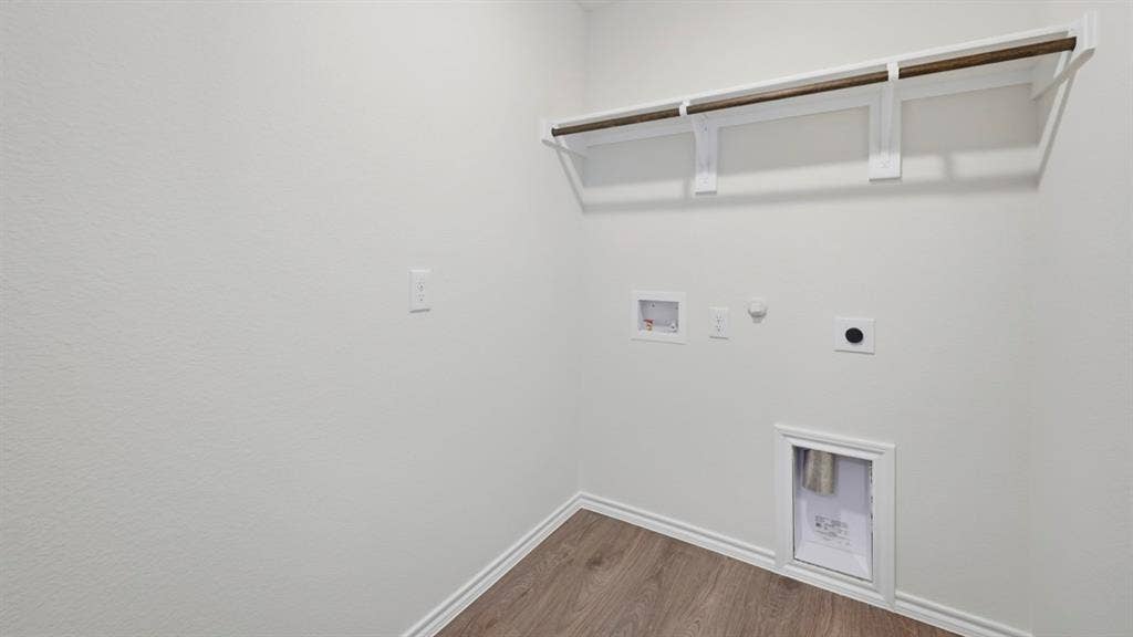 5032 Shumard Drive, Lindale, TX 75771 Utility space featuring wood-finish flooring, white walls, built-in shelving, and laundry hookups