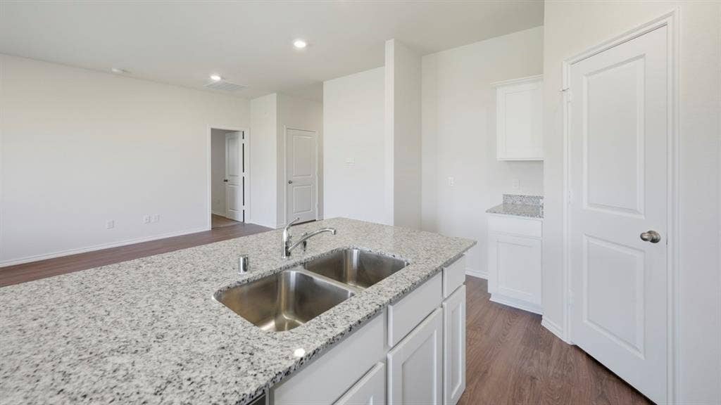 5032 Shumard Drive, Lindale, TX 75771 Kitchen island featuring a dual stainless steel sink and granite-style countertop
