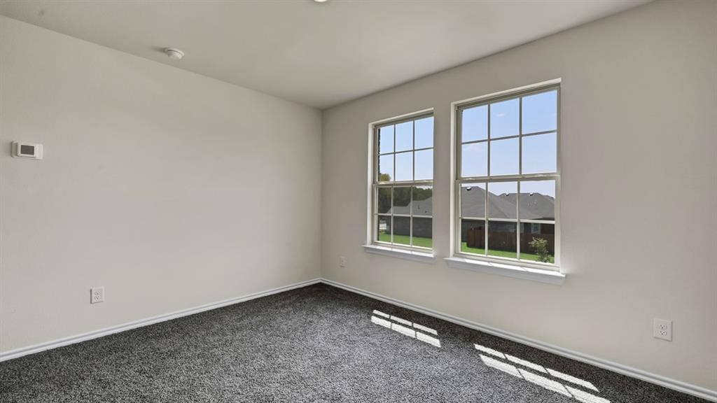 5024 Shumard Drive, Lindale, TX 75706 Room featuring two large windows, neutral wall paint, gray carpet flooring, white trim, and a ceiling light fixture
