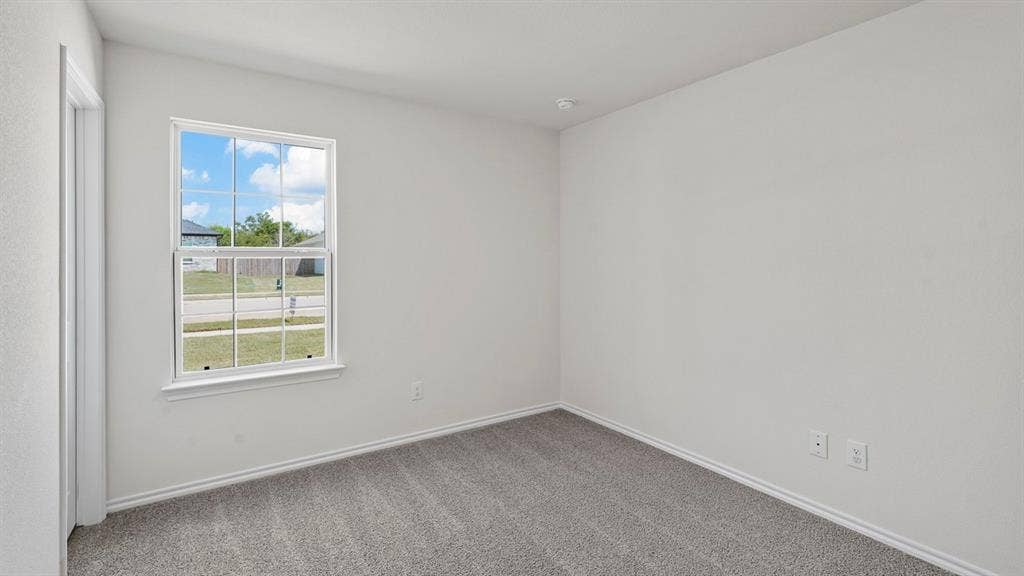 Room featuring neutral wall tones, gray carpeting, white baseboards, and a double-pane window with white trim