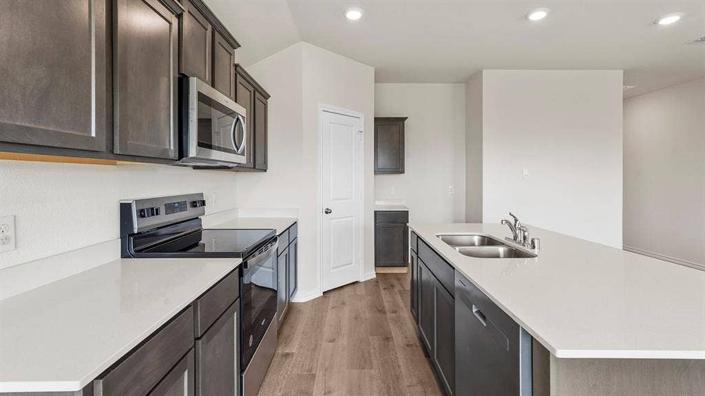 Modern kitchen featuring dark wood-finish cabinetry and light countertops