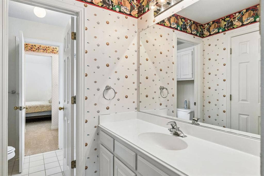 3809 Brookfield Drive, Plano, TX 75025 Featuring a tub and shower combination perfect for a relaxing soak or a quick rinse, plus a vanity with ample cabinet storage to keep all your essentials neatly tucked away.