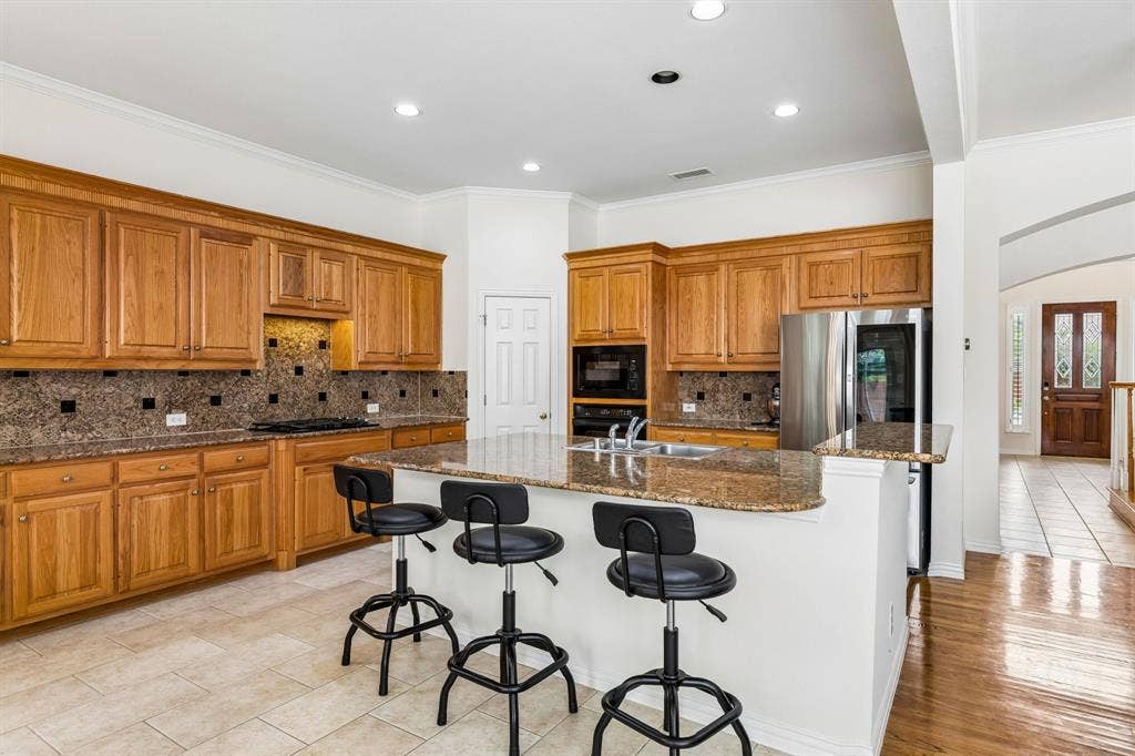 3809 Brookfield Drive, Plano, TX 75025 Indulge in the culinary delight of the chef's kitchen, where a spacious eat-in island takes center stage, inviting you to gather and create cherished memories in this open and generously proportioned space.