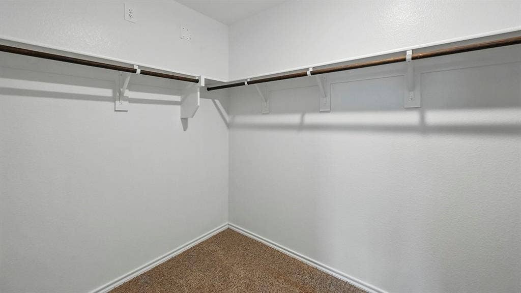 5008 Shumard Drive, Lindale, TX 75771 Walk-in closet featuring white walls, carpet flooring, and a corner hanging rod system