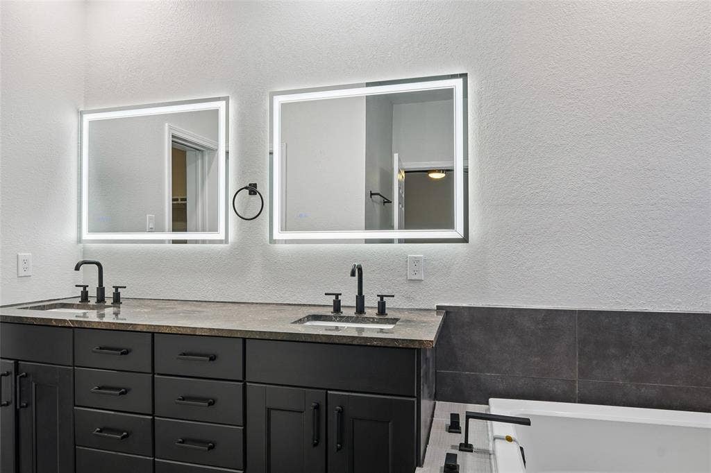Dual vanity with stone countertop, undermount sinks, and matte black fixtures