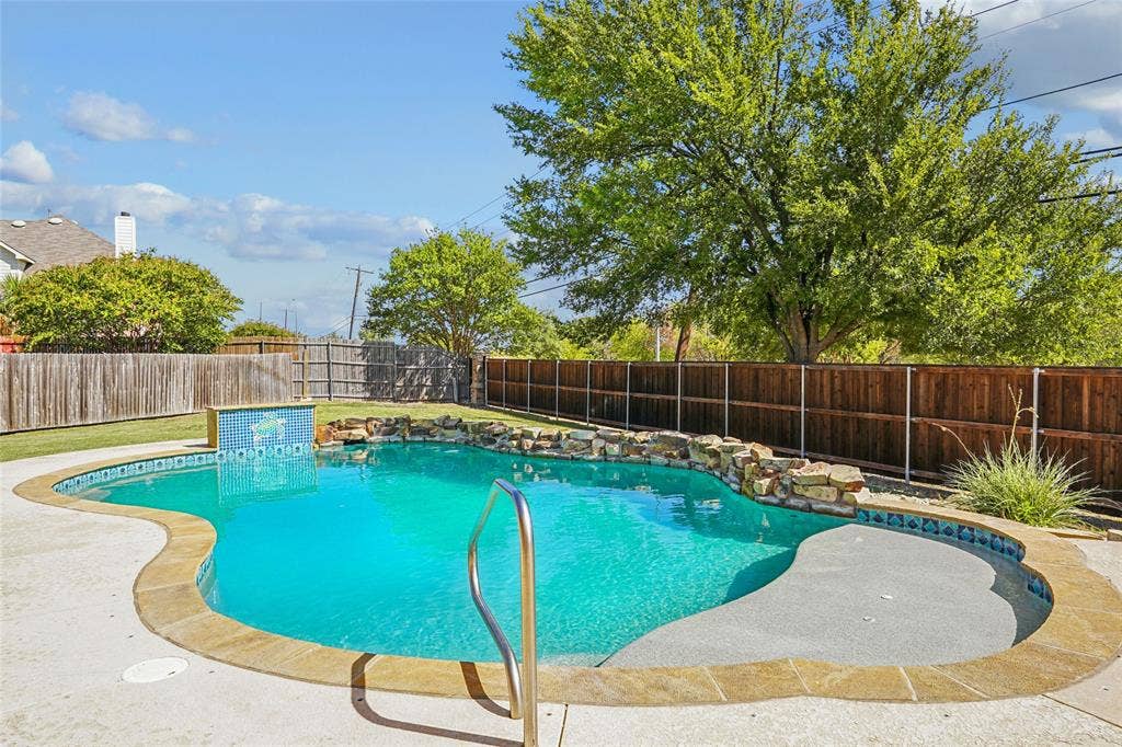 Freeform swimming pool with a stone coping and integrated rock features
