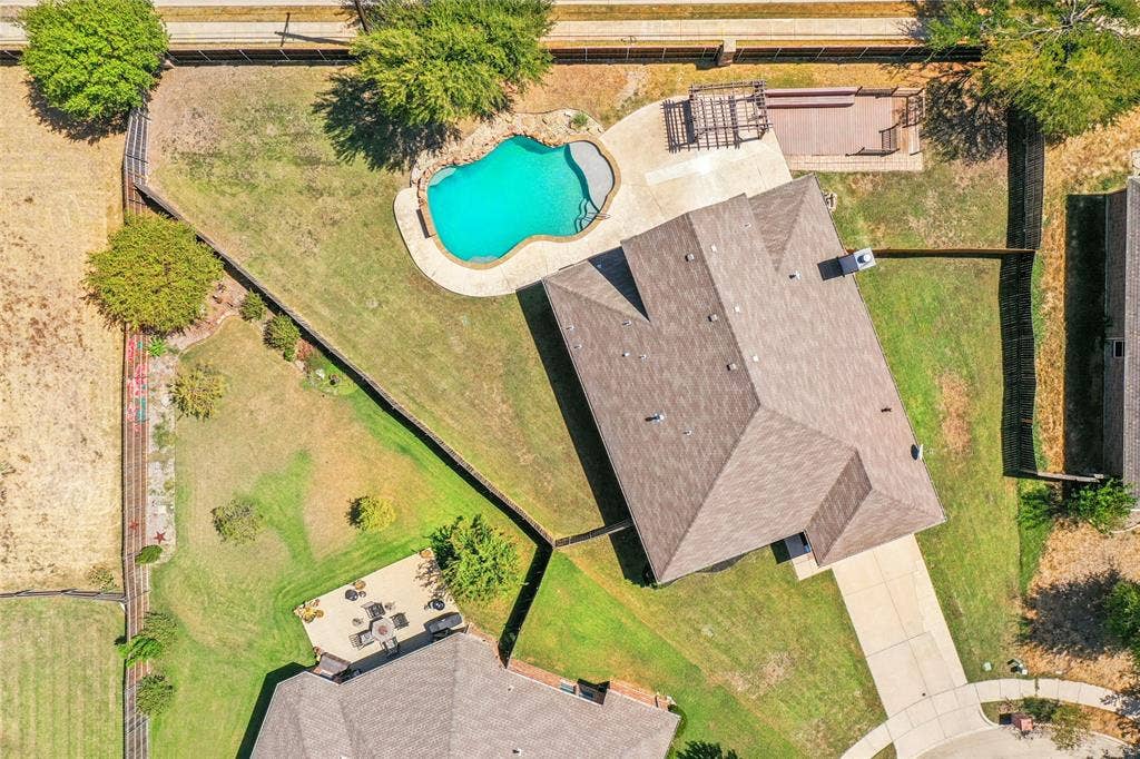 Large lot with a freeform swimming pool, paved pool deck, and a multi-level wood deck