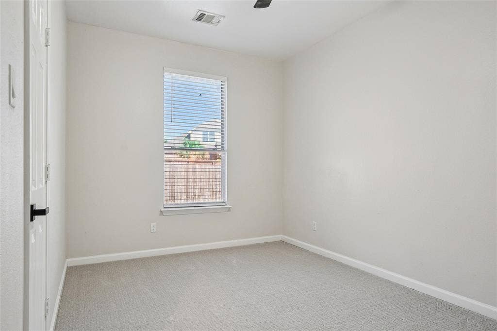 Neutral wall color, light gray carpet, and a window with blinds