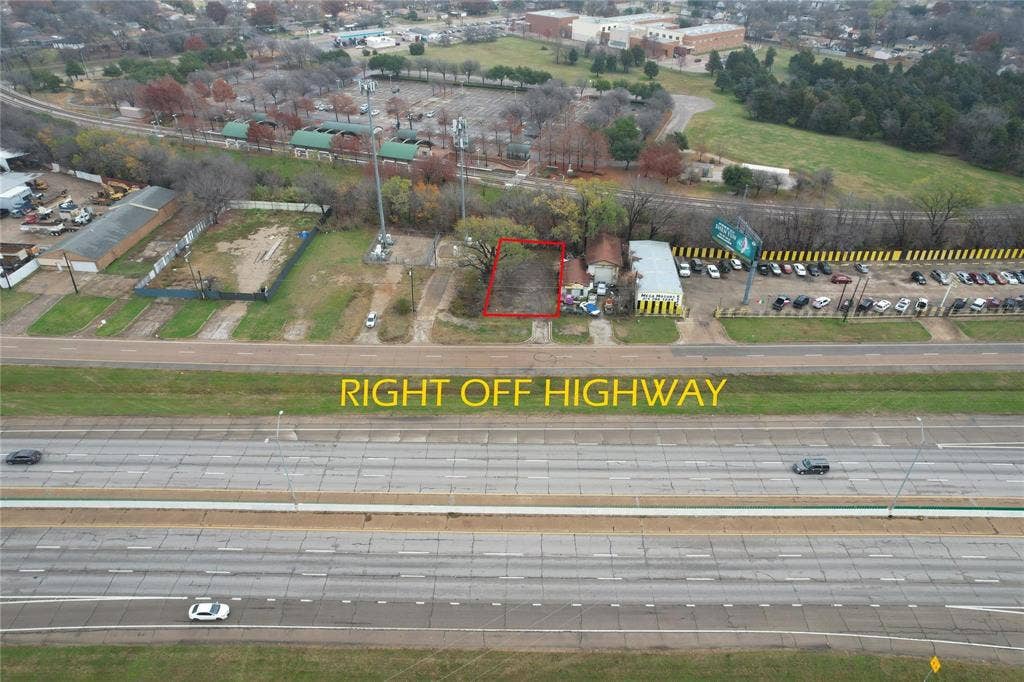 6518 C F Hawn Freeway, Dallas, TX 75217 Aerial perspective showcasing a vacant parcel of land, clearly outlined in red, positioned directly adjacent to a multi-lane highway