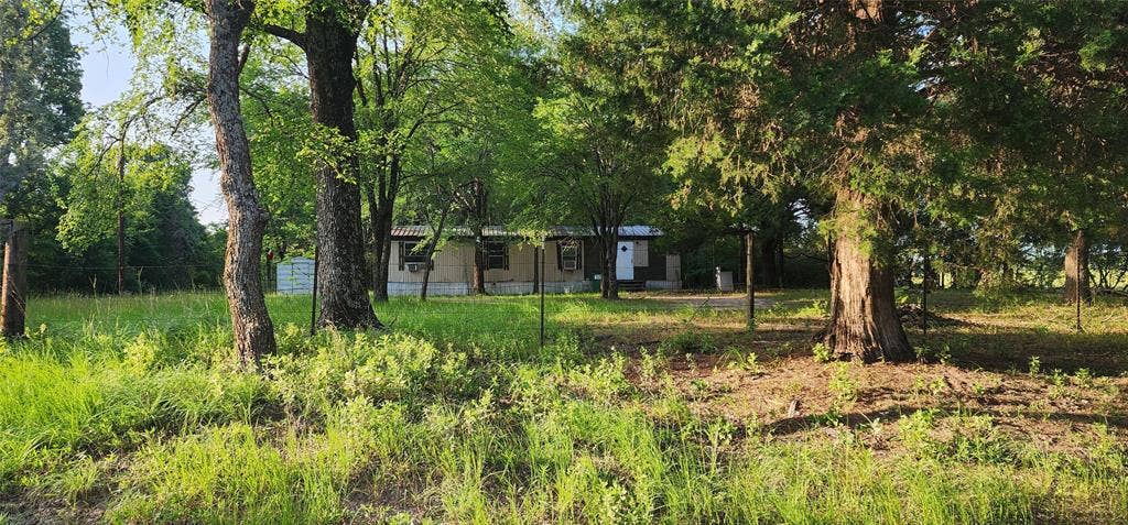 14598 County Road 1122, Athens, TX 75751 Single-story residence set amidst mature trees and natural landscaping