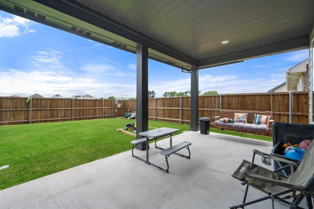 2325 Volans Drive, Haslet, TX 76052 Covered patio with a concrete surface, featuring dark support columns and a ceiling fan