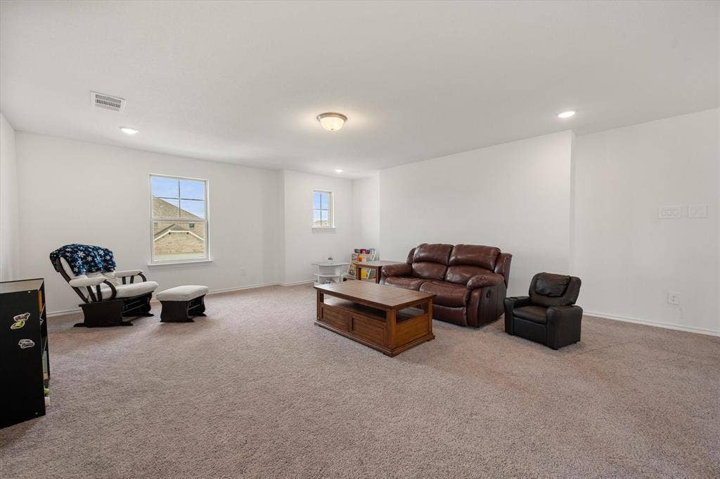 2325 Volans Drive, Haslet, TX 76052 Spacious room featuring neutral carpet flooring, white walls, multiple windows, recessed lighting, and a central ceiling light fixture